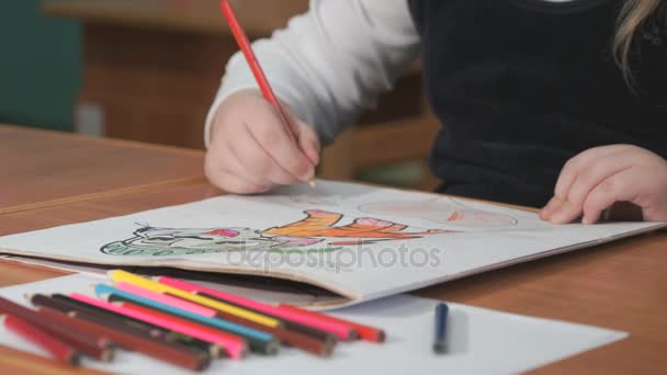 Little girl draws the pictures using color pencils - Footage, Video