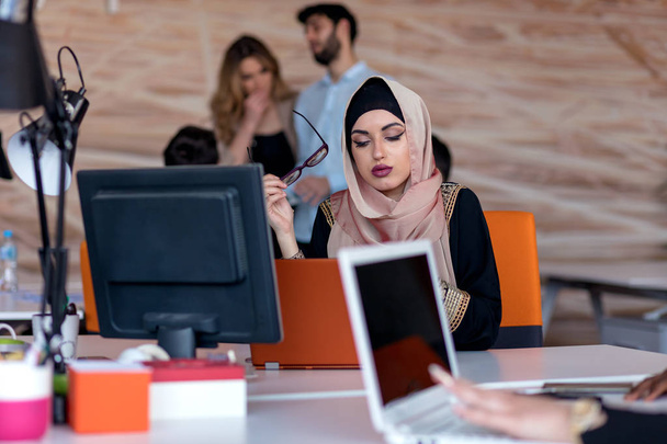 Attractive Muslim young woman working in office on computer - Foto, immagini