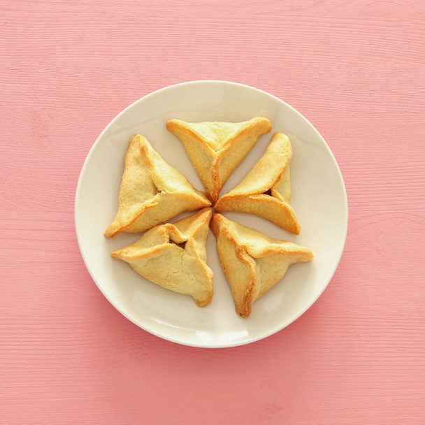 Purim celebration concept (jewish carnival holiday). Traditional hamantaschen cookies. Top view. - 写真・画像