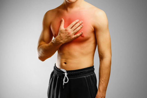 Facet bez koszuli, trzymając rękę klatki piersiowej pacjenta. Ból  - Zdjęcie, obraz