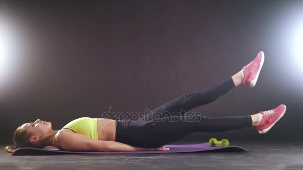 Εξάσκηση γυμναστήριο. Όμορφη γυναίκα σε αθλητικά ρούχα προπόνησης για κοιλιακούς στο studio - Πλάνα, βίντεο