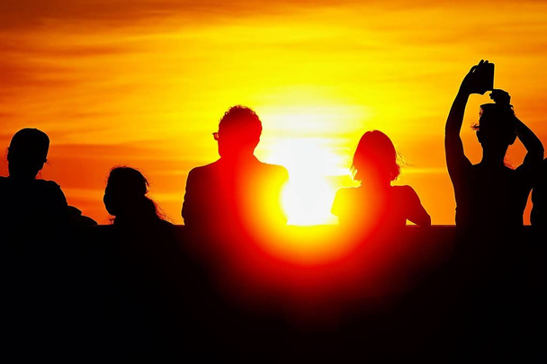 Silhouette von Menschen beobachten den Sonnenuntergang über Sonnenuntergang Zeit goldenen Himmel Hintergrund.                       - Foto, Bild