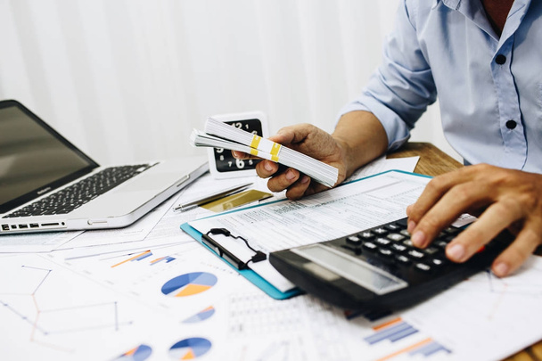Бухгалтер-бизнесмен использует калькулятор для расчета бюджетного налогового кредита
. - Фото, изображение