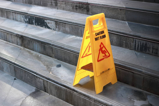 Panneau de sol humide jaune prudence à l'escalier de la ville extérieure
. - Photo, image