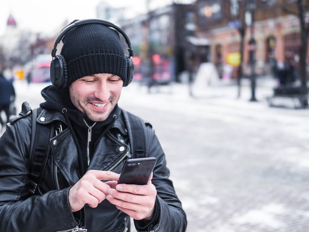 kulaklıklar, sokakta yürürken ve onun smartphone kullanarak turist. Canlı aktif yaşam tarzı. - Fotoğraf, Görsel