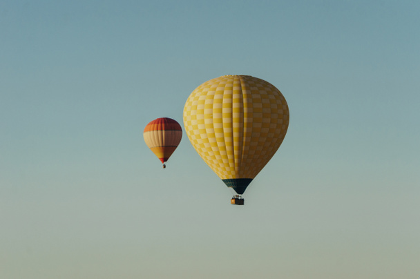 Воздушные шары, летящие в голубом небе
 - Фото, изображение