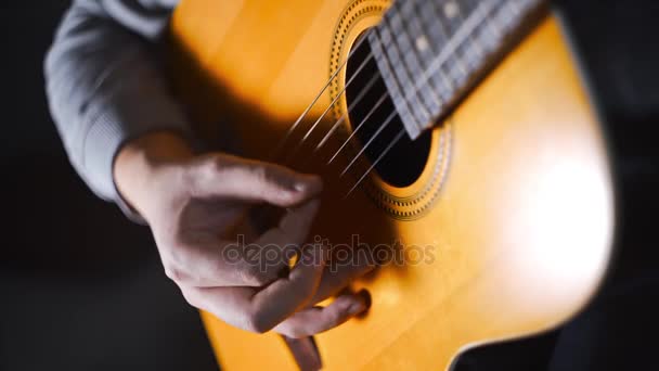 Гитарист играет гаммы и гаммы на акустической западной гитаре со стальными струнами, собирая технику, упражнения и арпеджио, видео со звуком, щёлкая гитару, музыкальный инструмент
 - Кадры, видео