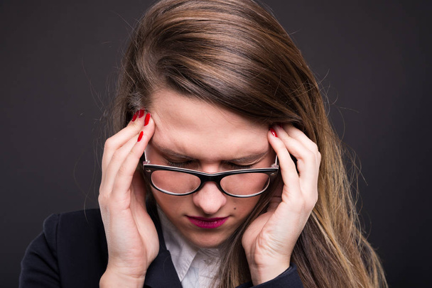Mujer de negocios infeliz que sufre de fuerte dolor de cabeza
 - Foto, imagen
