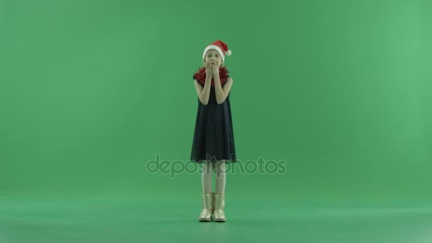 Cute little girl in Christmas hat sends air kisses, chroma key on background - Footage, Video