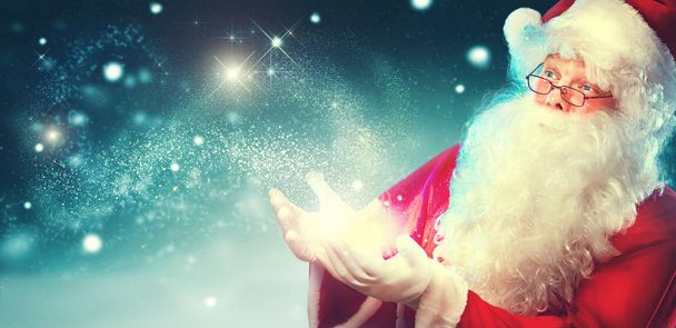 Happy Santa Claus with magic lights on blue background - Foto, imagen