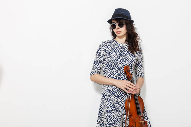 Young woman with dark glasses and a violin in her hand - Фото, изображение