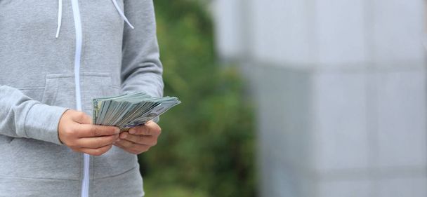 Female hands counting money on blurred city background - Zdjęcie, obraz