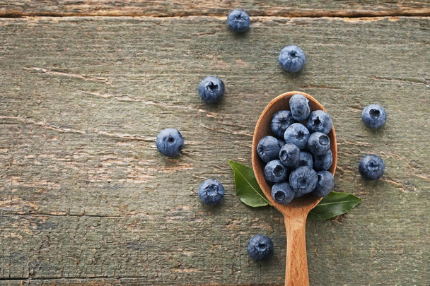 Ripe blueberries in wooden spoon - Fotografie, Obrázek