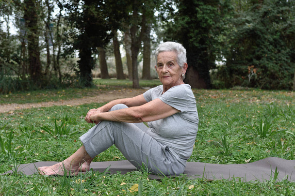 пожилая женщина практикует йогу на открытом воздухе
 - Фото, изображение