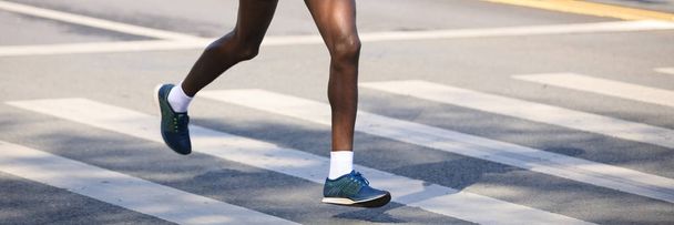 Ноги бігуна марафону біжать по міській дорозі
 - Фото, зображення