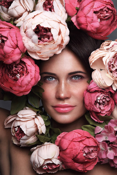 Portrait of young beautiful woman with flowers around her face - Zdjęcie, obraz