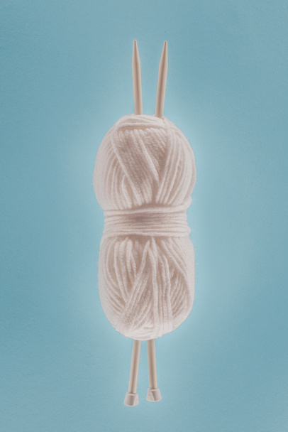 vue de dessus de boule de tricot blanche avec aiguilles à tricoter, isolée sur bleu
 - Photo, image
