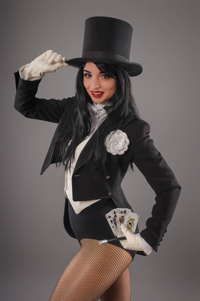 Female magician in performer suit with magic wand and playing ca - Φωτογραφία, εικόνα
