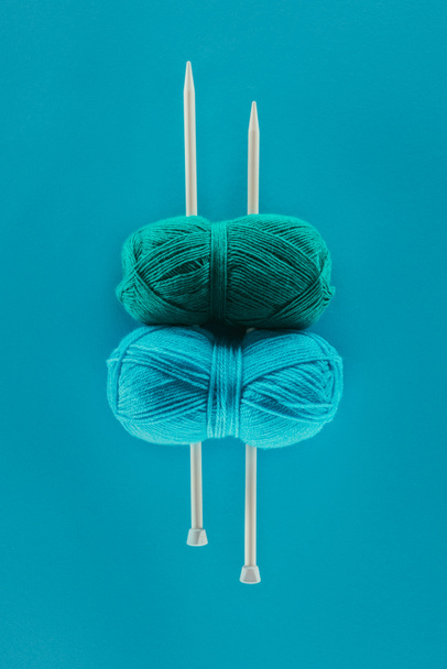 vue du dessus du fil à tricoter bleu avec aiguilles à tricoter, isolé sur bleu
 - Photo, image