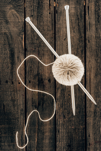 vista superior da bola de fio com agulhas de tricô no fundo de madeira
 - Foto, Imagem