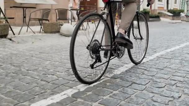 Imágenes de ángulo bajo de un joven con estilo que gira los pedales de la bicicleta mientras viaja al trabajo
 - Imágenes, Vídeo