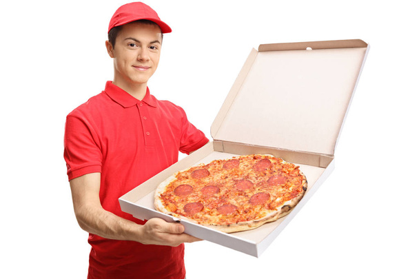 pizza delivery boy showing a pizza inside a box - Fotoğraf, Görsel