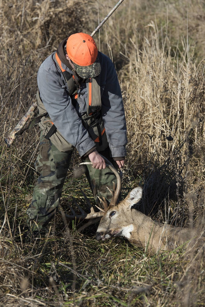 Um jovem caçador de veados com um troféu Whitetailed Deer
 - Foto, Imagem