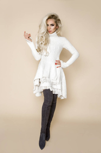 Красива, сексуальна блондинка з довгим волоссям, одягнена в яскраве плаття і довгі чоботи
 - Фото, зображення