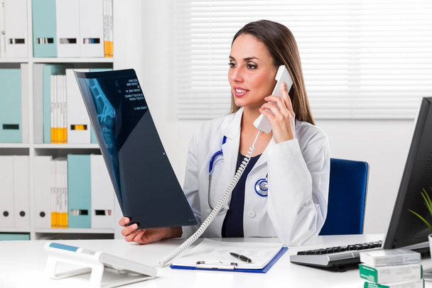 Medico donna che guarda le radiografie dei pazienti nel suo ufficio
 - Foto, immagini