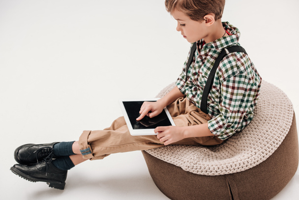 vista lateral del niño sentado y usando tableta digital con pantalla en blanco aislada en gris
 - Foto, imagen
