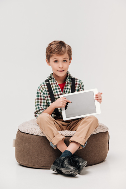mignon petit garçon montrant tablette numérique avec écran blanc et regardant caméra isolée sur gris
 - Photo, image
