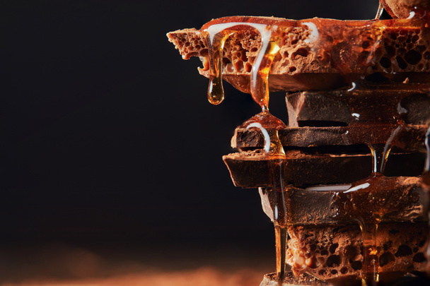 close up view of caramel on chocolate bars heap isolated on black - Φωτογραφία, εικόνα