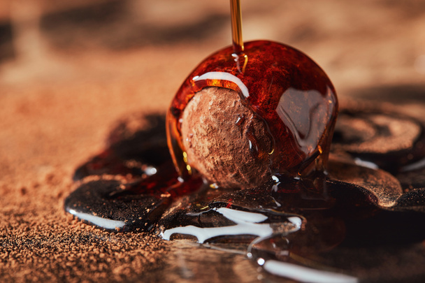 close up view of pouring caramel onto truffle process - Photo, Image