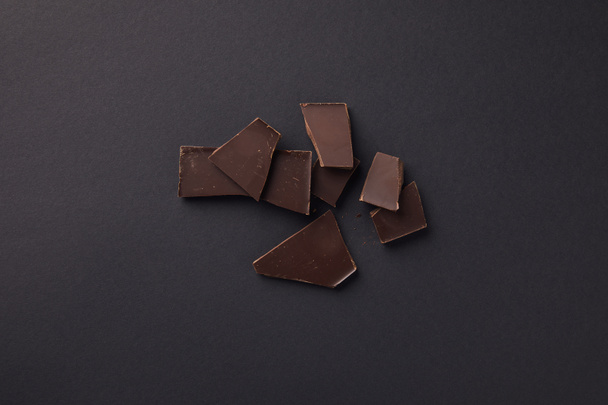 top view of dark chocolate bars on grey surface - Foto, afbeelding