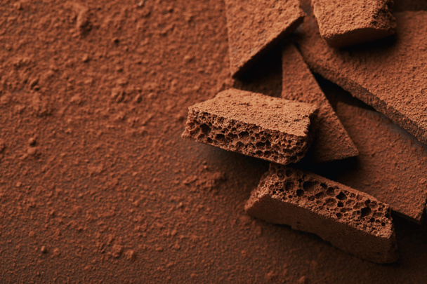 vista ravvicinata di mucchio di barrette di cioccolato in polvere di cacao
 - Foto, immagini