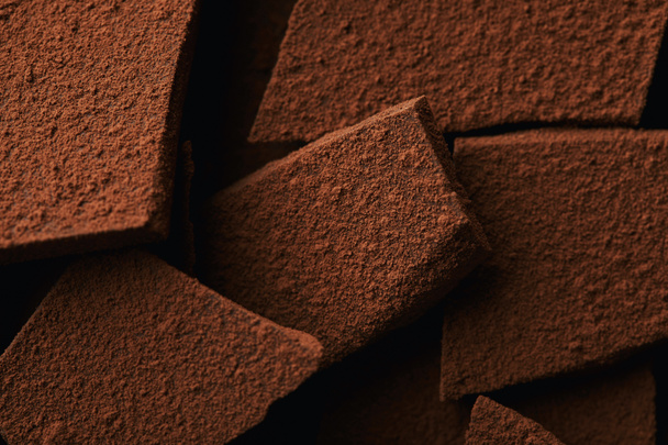 vista ravvicinata di mucchio di barrette di cioccolato in polvere di cacao
 - Foto, immagini
