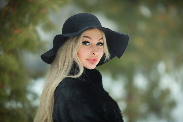 portrait of a beautiful young girl in a hat walking outdoors in cold weather - Fotografie, Obrázek