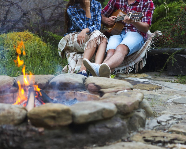 junges Paar mit Gitarre am Feuer im Freien - Foto, Bild