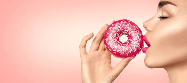fashion model girl holding sweet pink doughnut - Foto, imagen