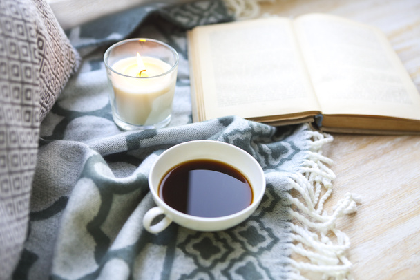 Kopje koffie, kaars en boek op de verdieping - Foto, afbeelding