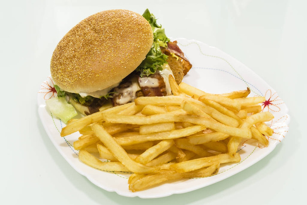 Гамбургер з картоплею на тарілці, виготовленої в домашніх умовах
 - Фото, зображення