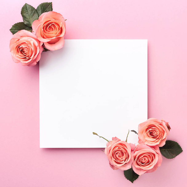 Σημείωση κενό χαρτί και τριαντάφυλλα σε ροζ φόντο - Φωτογραφία, εικόνα