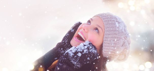 Smiling young girl portrait under snowfall - Photo, image