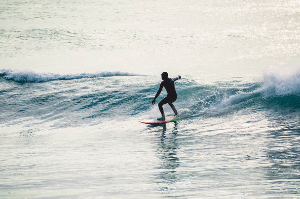 Surfař jízda na dokonalé oceánu vlnu při západu slunce. Zima surfování v plavkách   - Fotografie, Obrázek