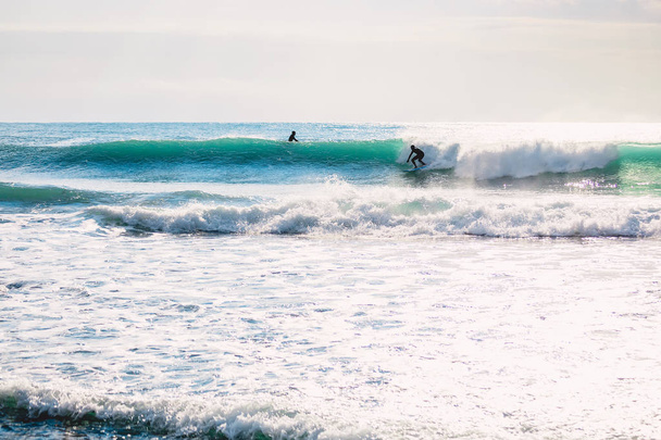 Surfez sur une vague océanique parfaite au coucher du soleil. Surf d'hiver en maillot de bain
   - Photo, image