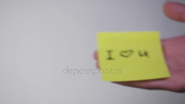 Inscrição no autocolante que te amo. Desenho "Amo-te" e coração em papel amarelo. Inscrição Eu te amo no adesivo no vidro
 - Filmagem, Vídeo