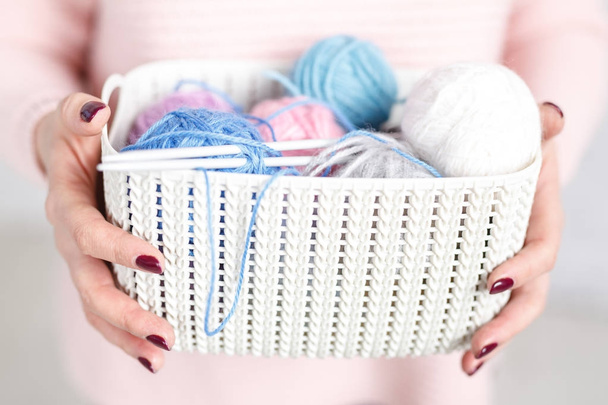 woman holds a plastic organizer basket with tangles for knitting - Foto, Imagem