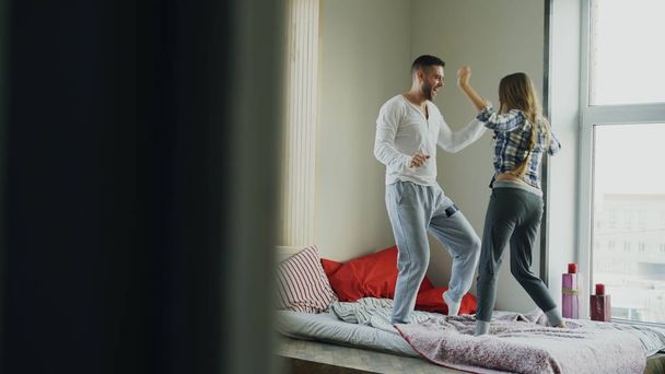 Young beautiful and loving couple dancing rocknroll dance on bed in the morning at home - Fotoğraf, Görsel