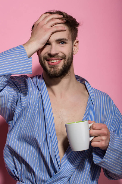 Bachelor in blue dressing gown smile with mug - 写真・画像