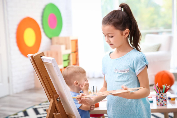 Little girl painting on canvas at home - Φωτογραφία, εικόνα